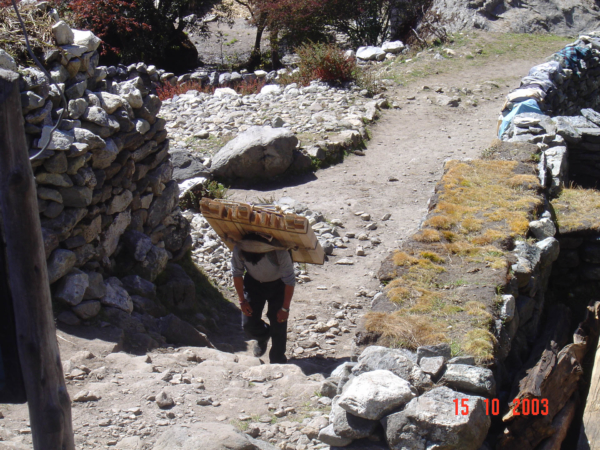 Pangboche a sherpa se stavebním materiálem.