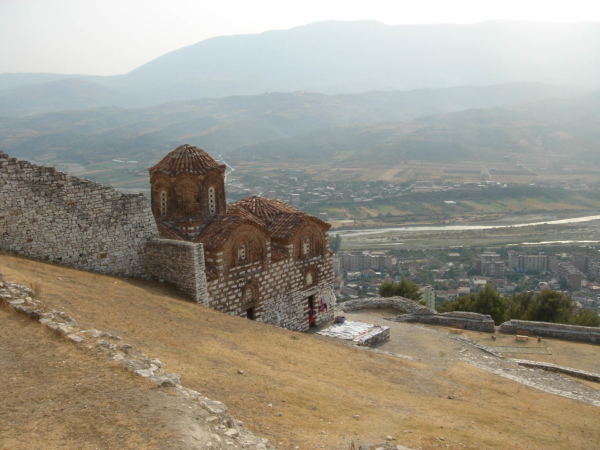 Zbytky byzantského kostela s městem v pozadí.
